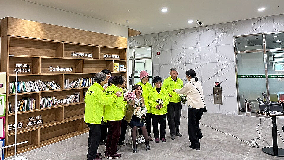 청양군노인종합복지관 강미희 관장과 2025년 노인 일자리 및 사회활동 지원사업에 참여한 어르신들이 성과보고회를 기념하며 함께 기념촬영을 하고 있는 모습.